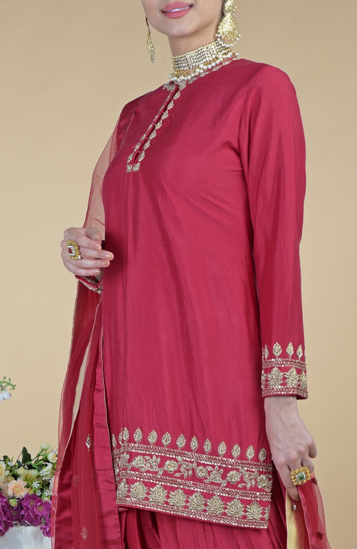 Red Zardozi Hand Embroidered Salwar Suit with gold embroidery and jewelry.