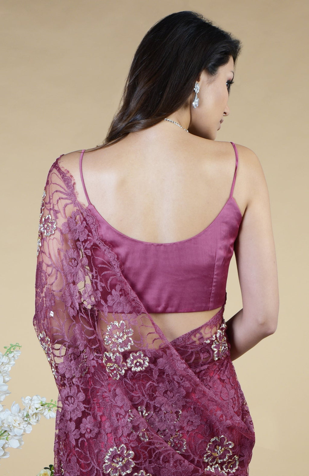 Woman in a wine French Chantilly hand-embroidered saree with a matching sleeveless blouse.