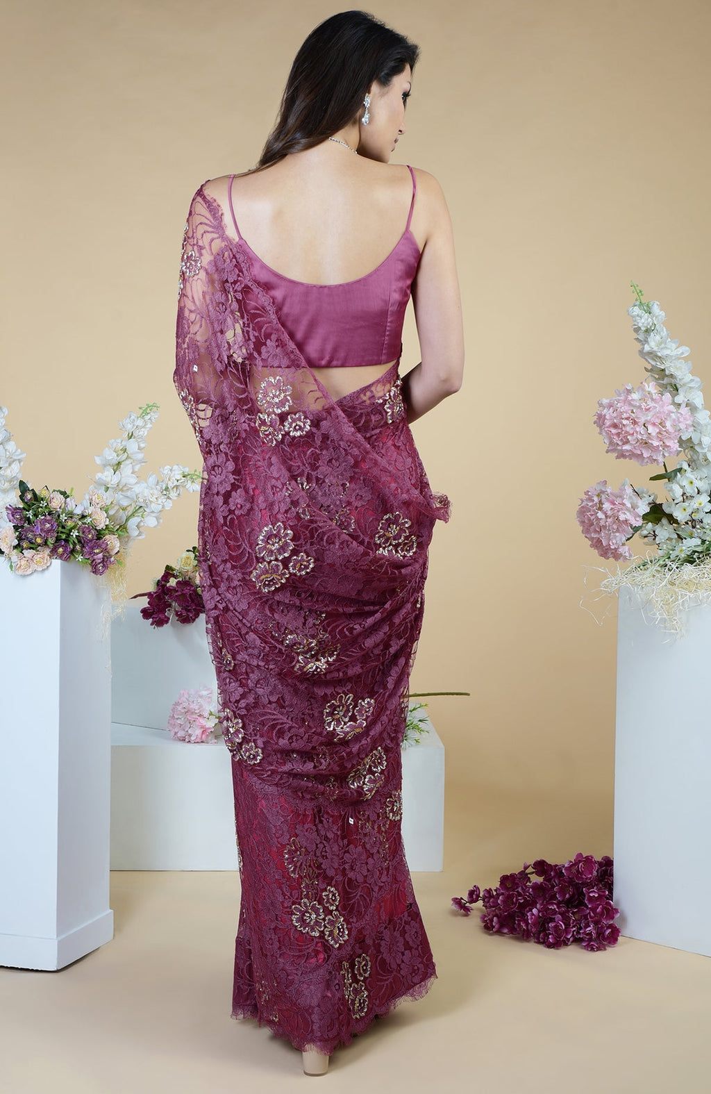 Woman in a wine French Chantilly hand-embroidered saree with a matching blouse.