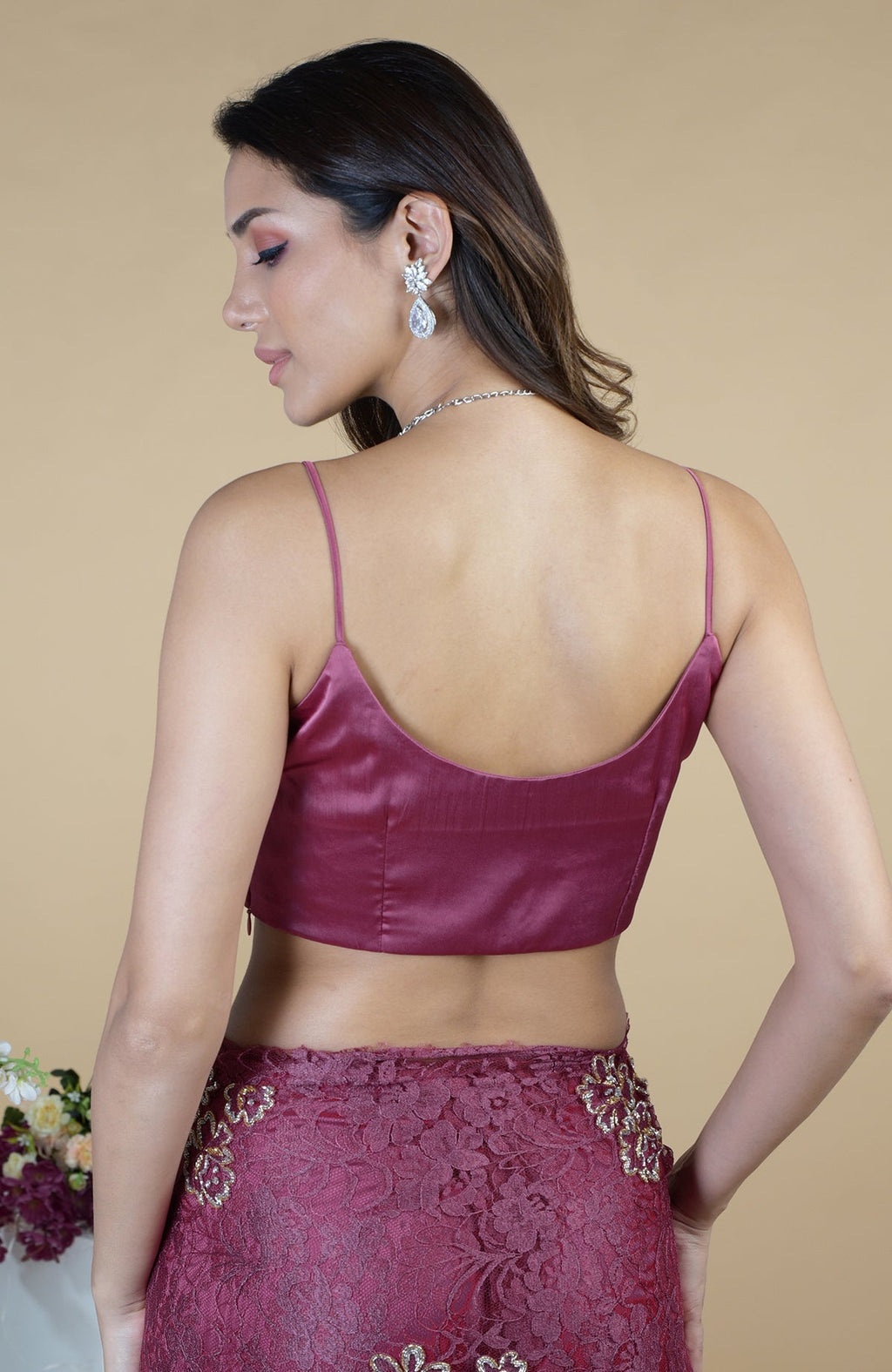A woman models a wine French Chantilly hand-embroidered saree with a satin-silk blouse.