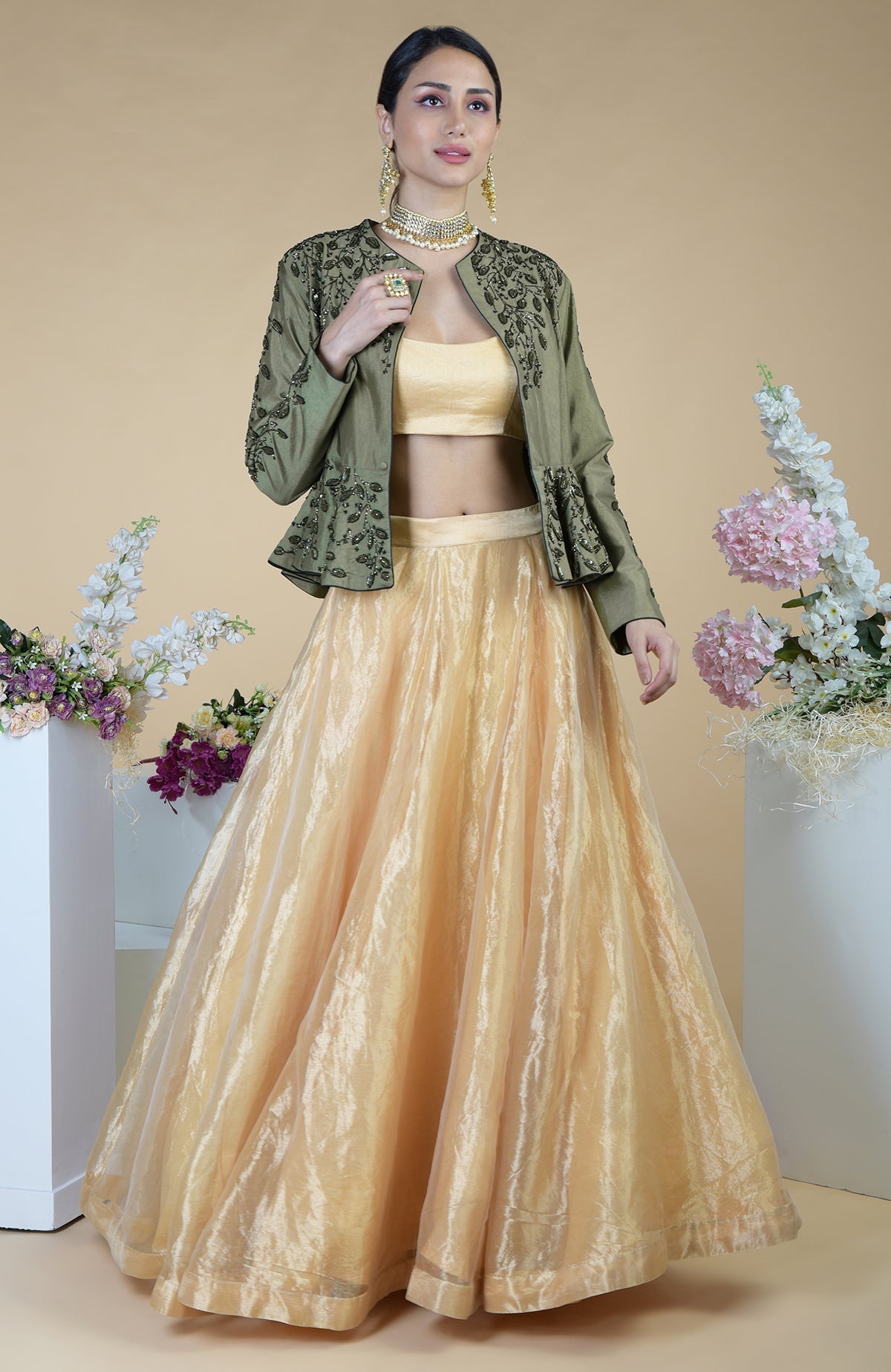 A woman models a dark foliage hand-embroidered peplum and skirt set.