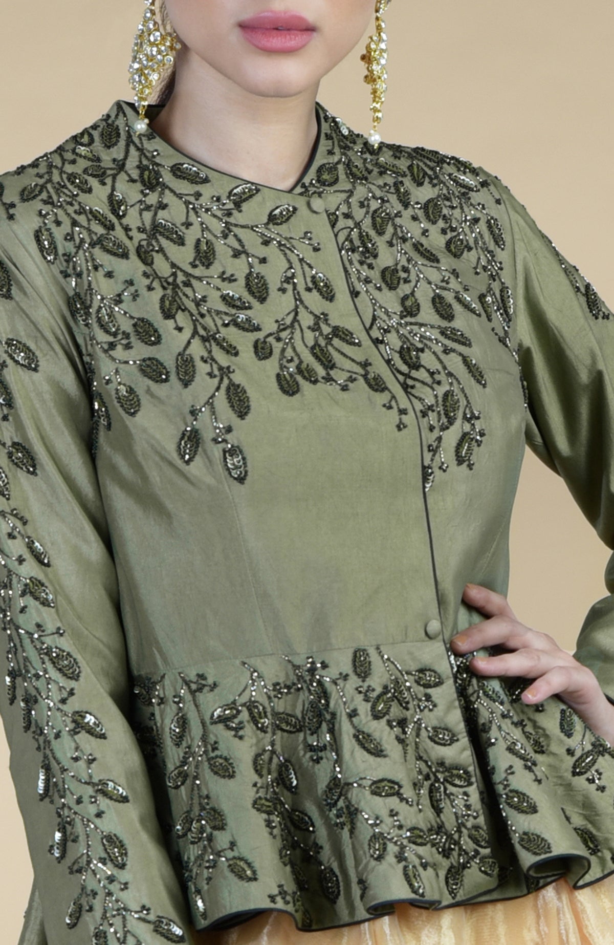 A woman models a dark foliage hand-embroidered peplum and skirt set.