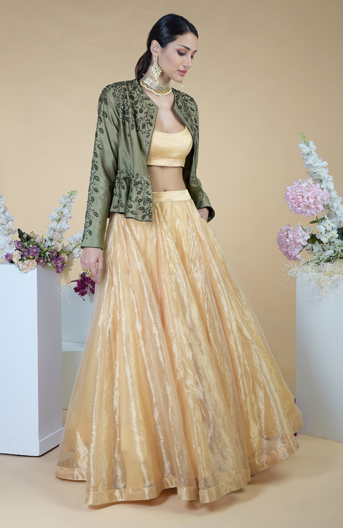 A woman models a dark foliage hand-embroidered peplum and skirt set.