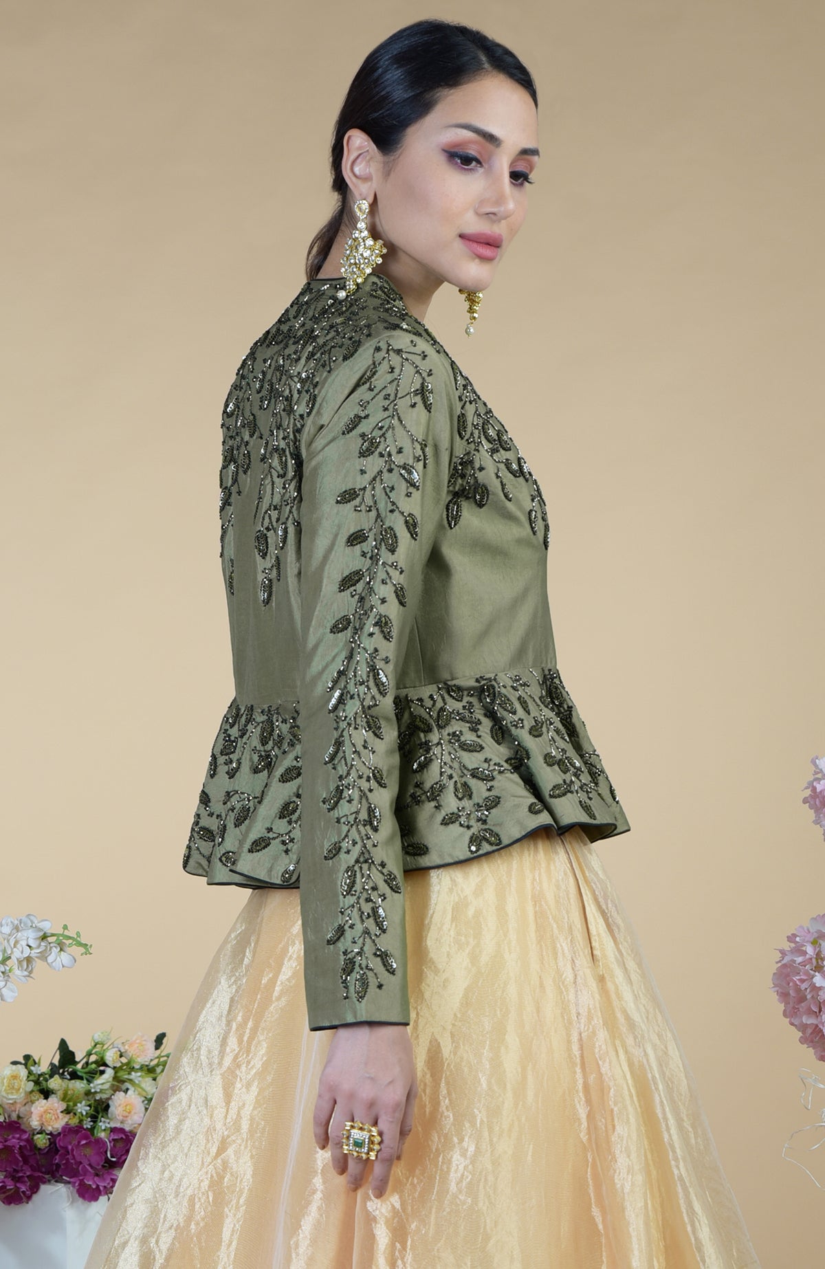 A woman models a dark foliage hand-embroidered peplum and skirt set.