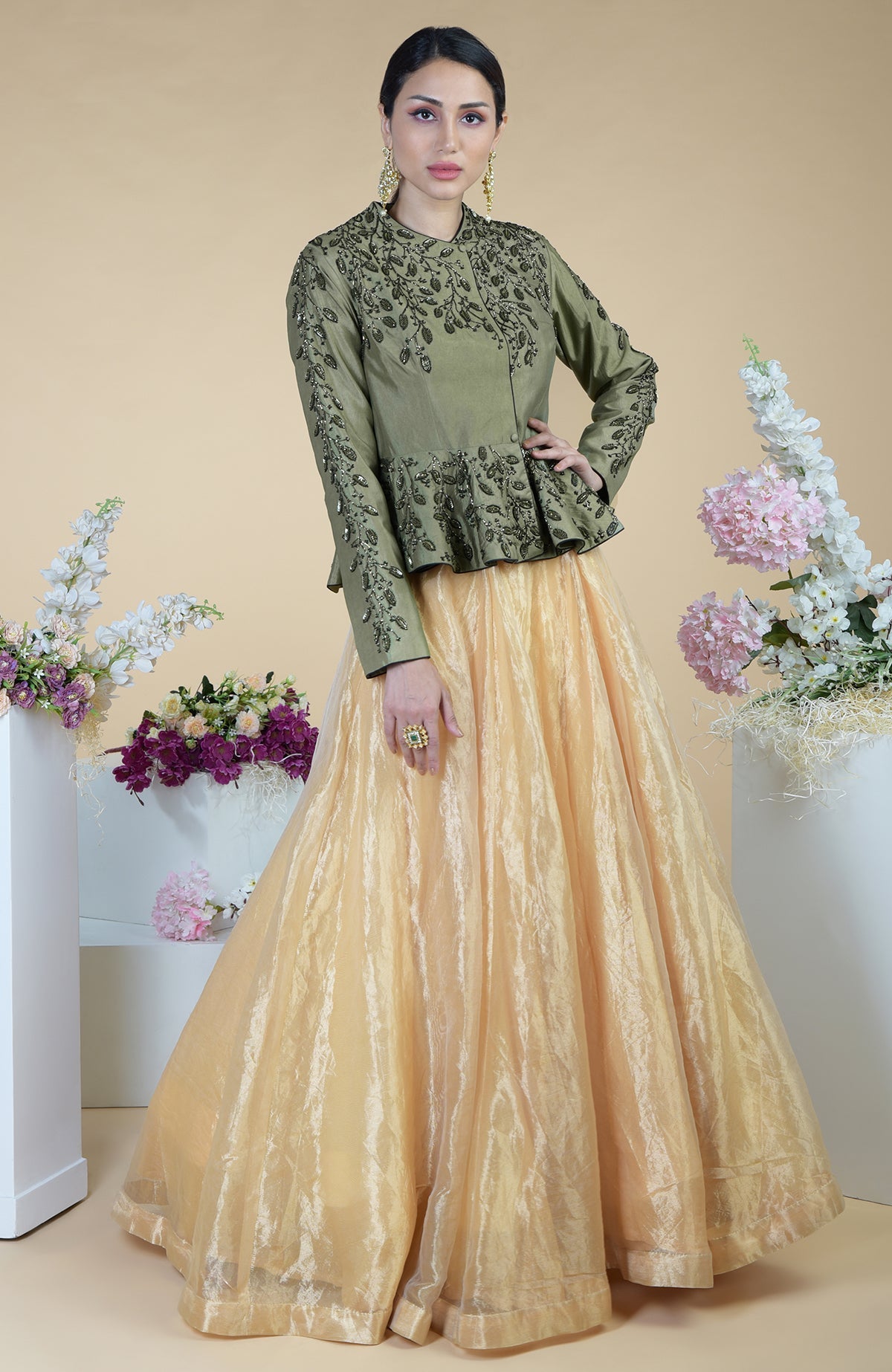 A woman models a dark foliage hand-embroidered peplum and skirt set.