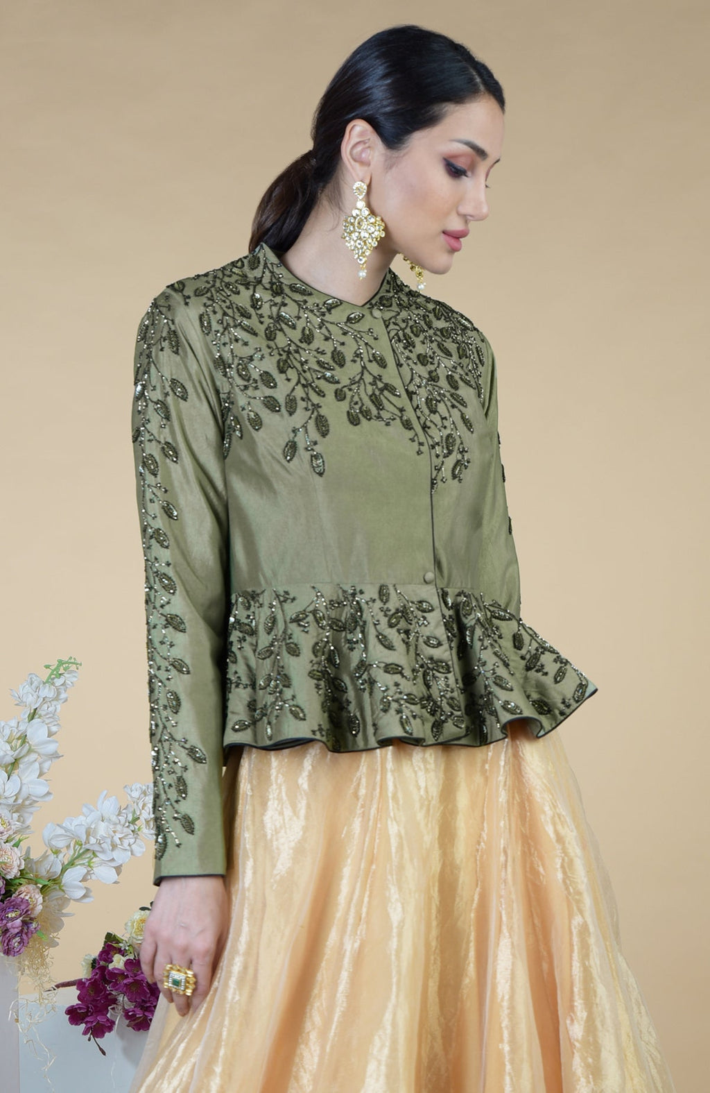 A woman models a dark foliage hand-embroidered peplum top and skirt set.
