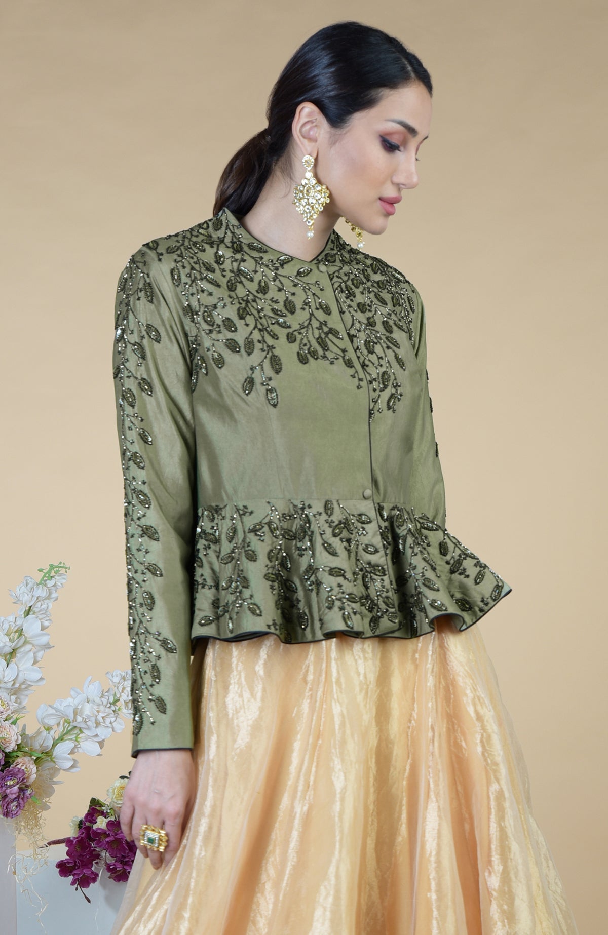 A woman models a dark foliage hand-embroidered peplum top and skirt set.