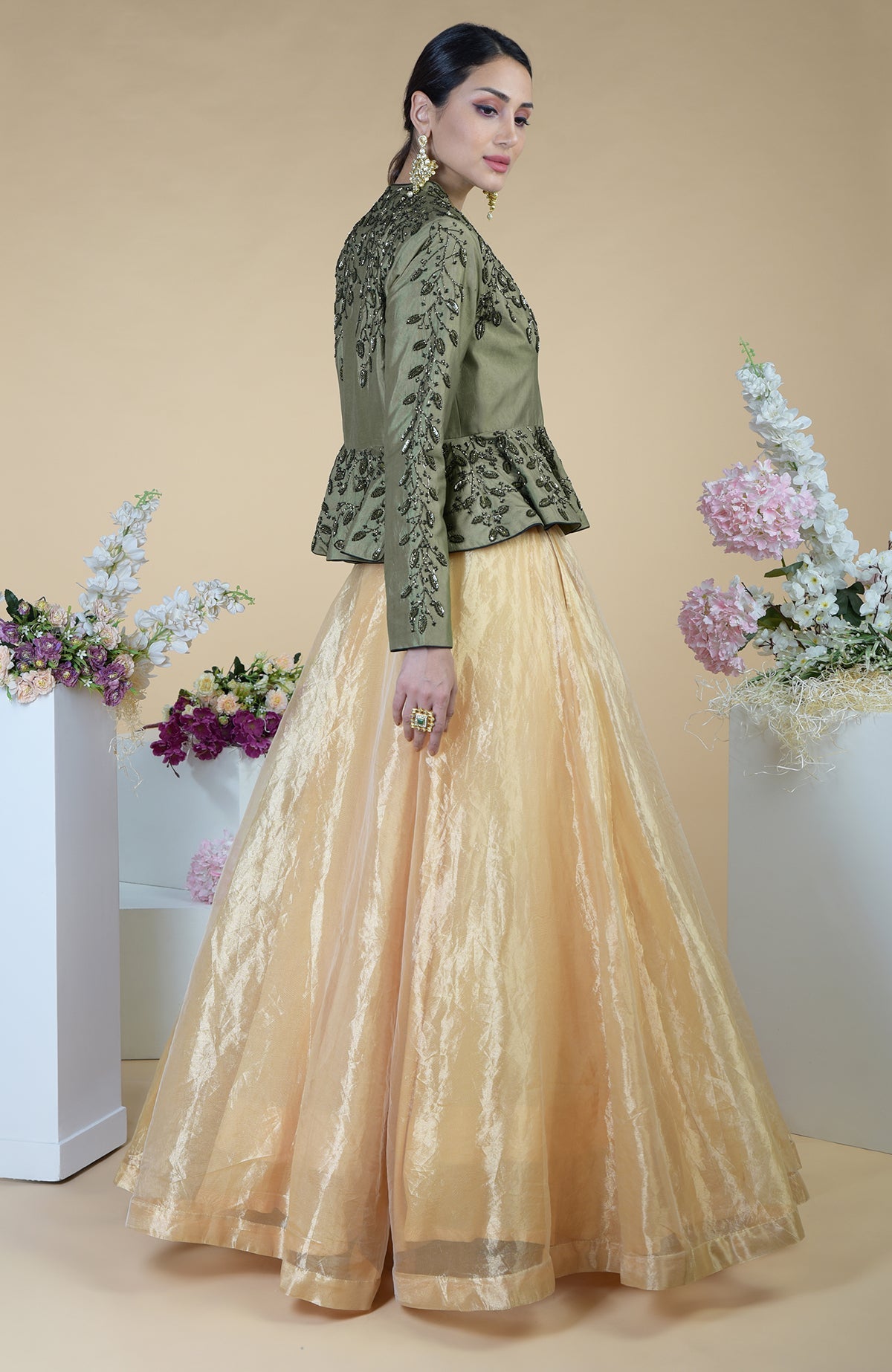 A woman models a dark foliage hand-embroidered peplum and skirt set.