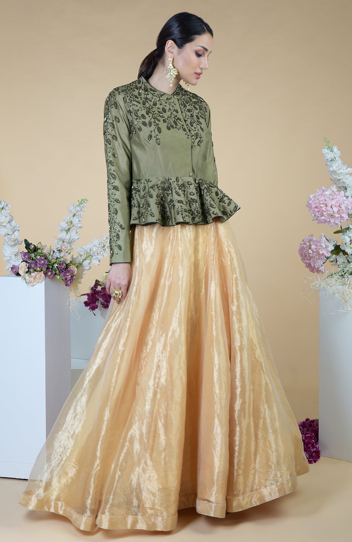 A woman models a dark foliage hand-embroidered peplum and skirt set.