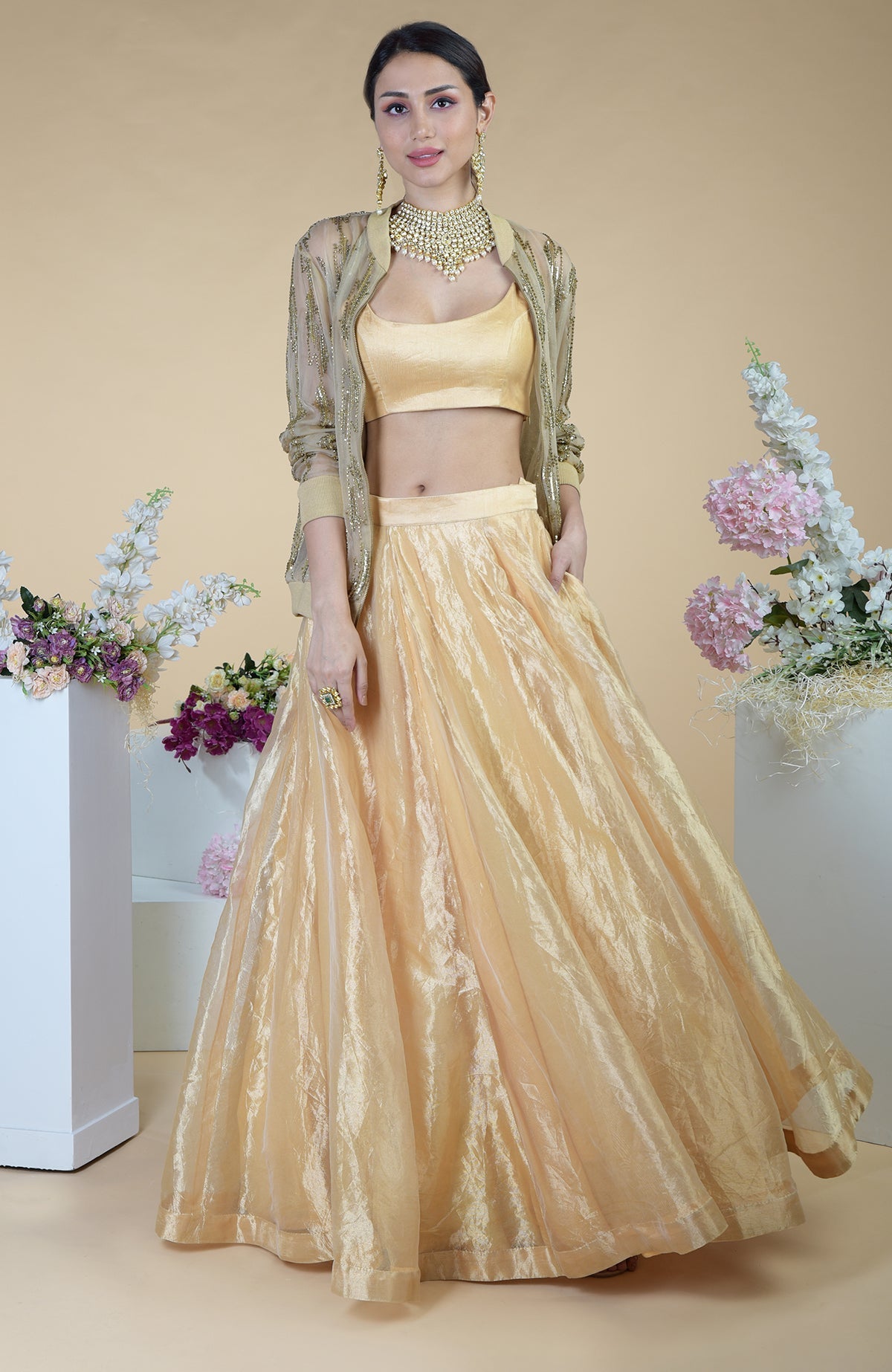 A woman models an Urban Vogue hand-embroidered cape and skirt set in gold.