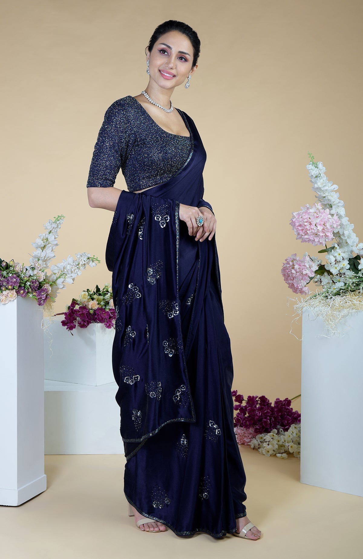A woman models a midnight blue bead and sequin hand-embroidered saree.