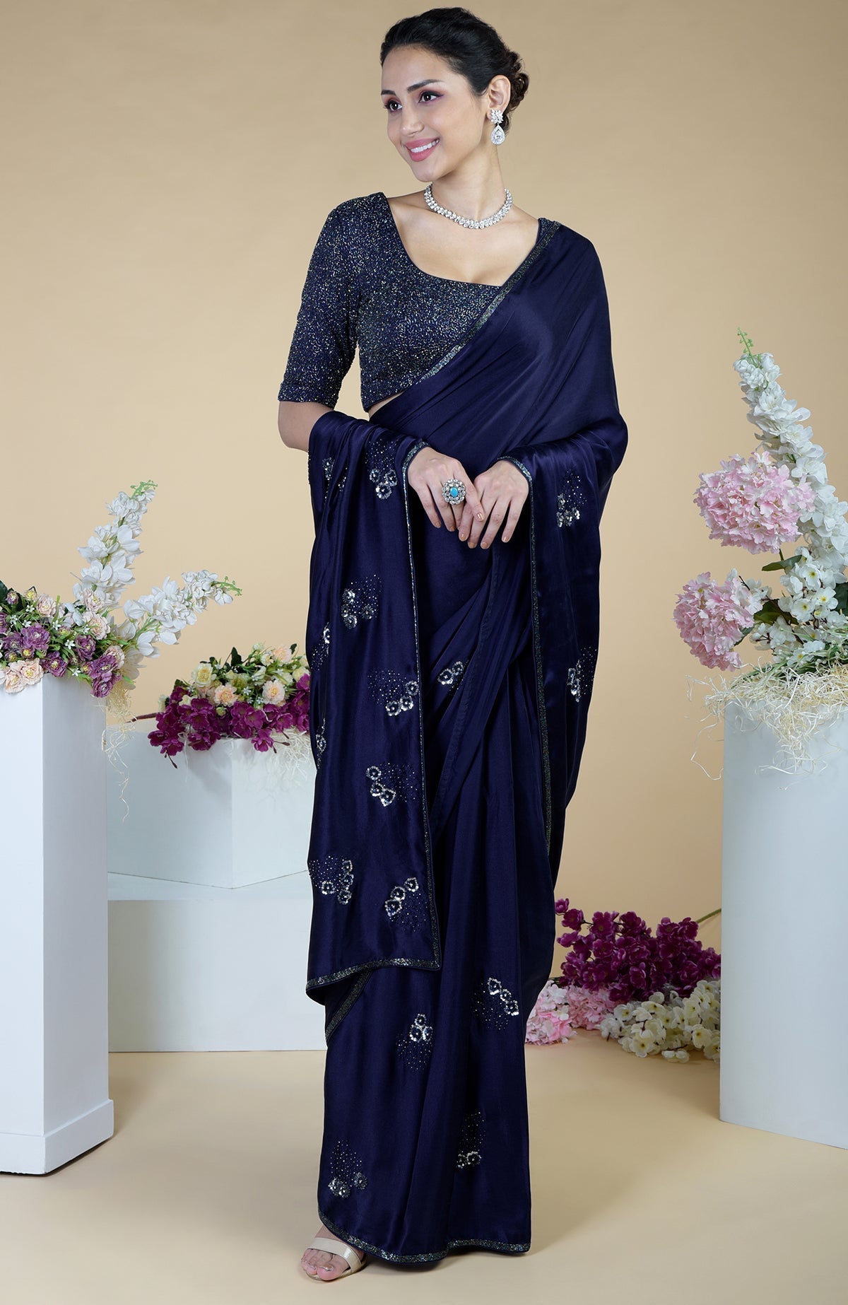 A woman models a midnight blue bead and sequin hand-embroidered saree.