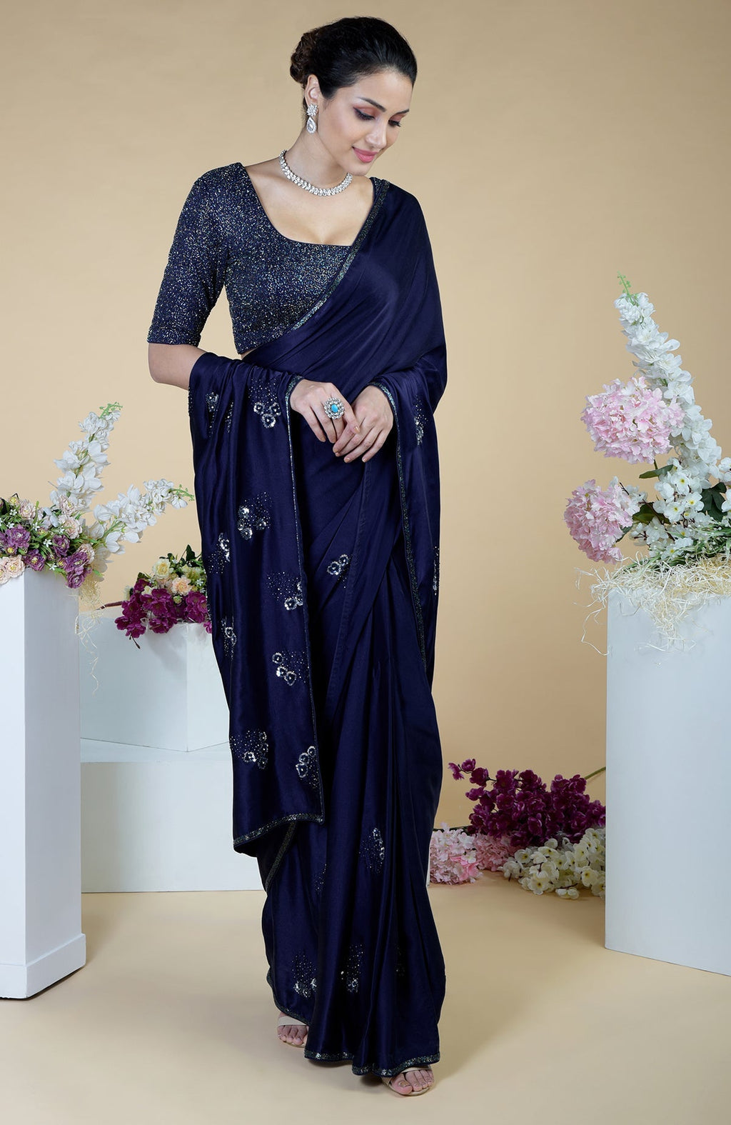 A woman in a midnight blue bead and sequin hand-embroidered saree.