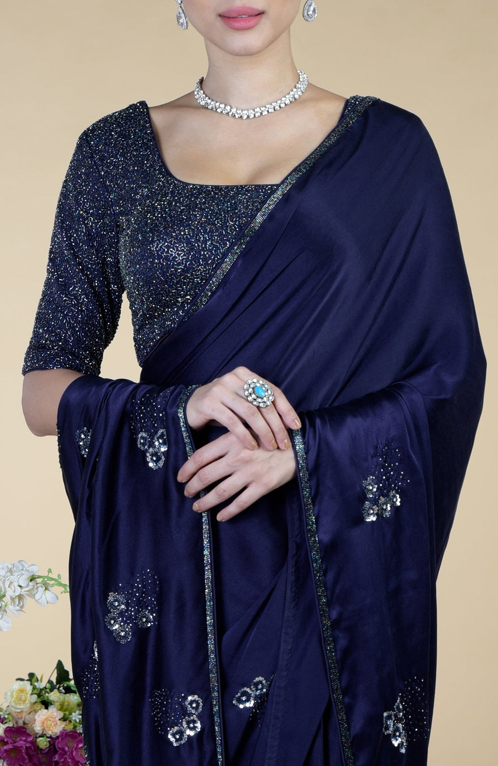 A woman models a midnight blue saree with bead and sequin embroidery.