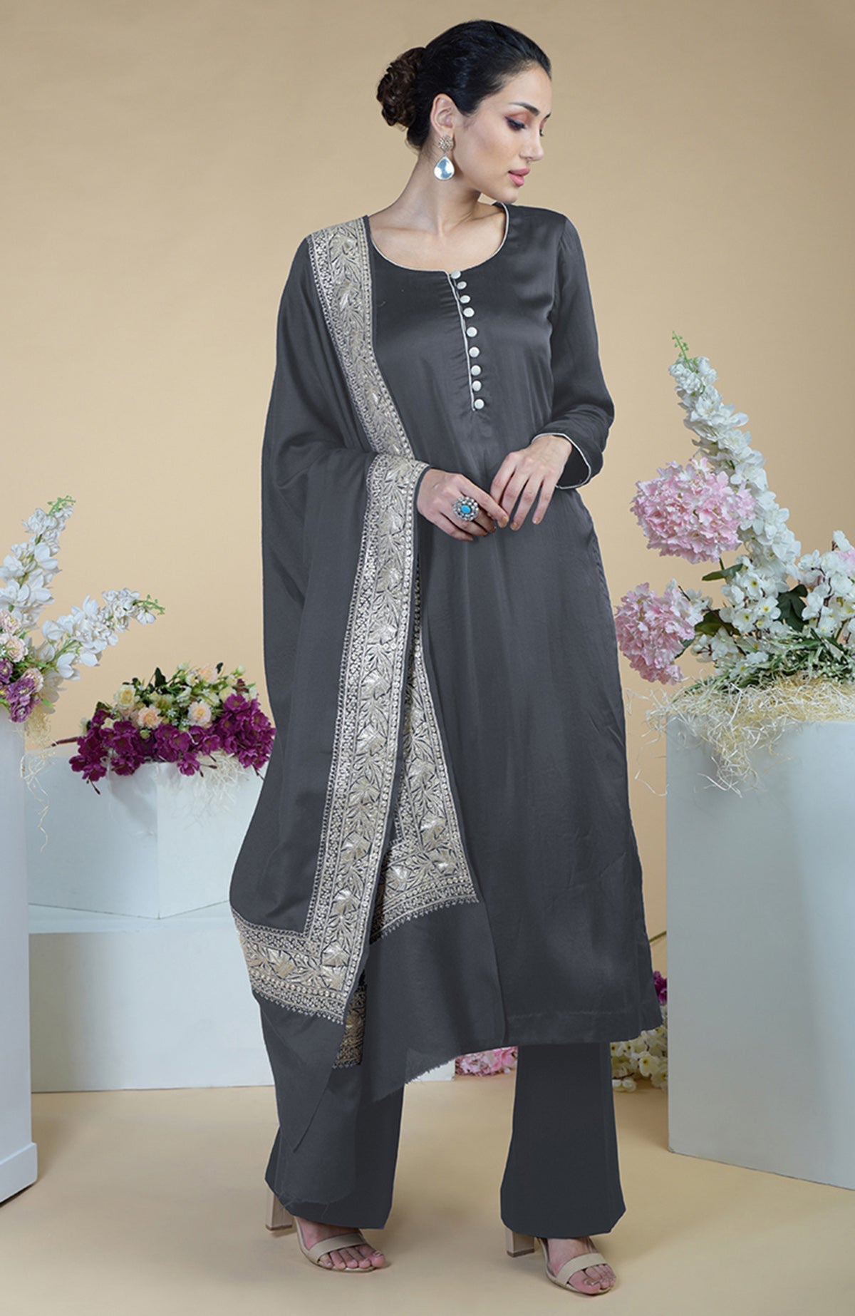 A woman models a grey Kashmiri Tilla embroidered silk dupatta with a matching suit.