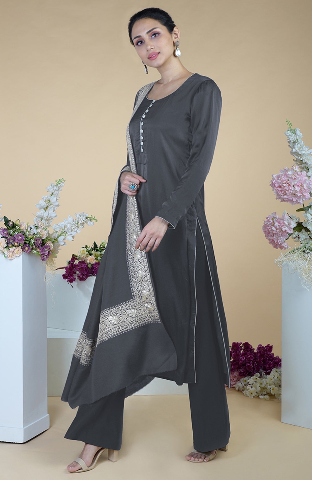 A woman models a grey Kashmiri Tilla embroidered silk dupatta and suit set.