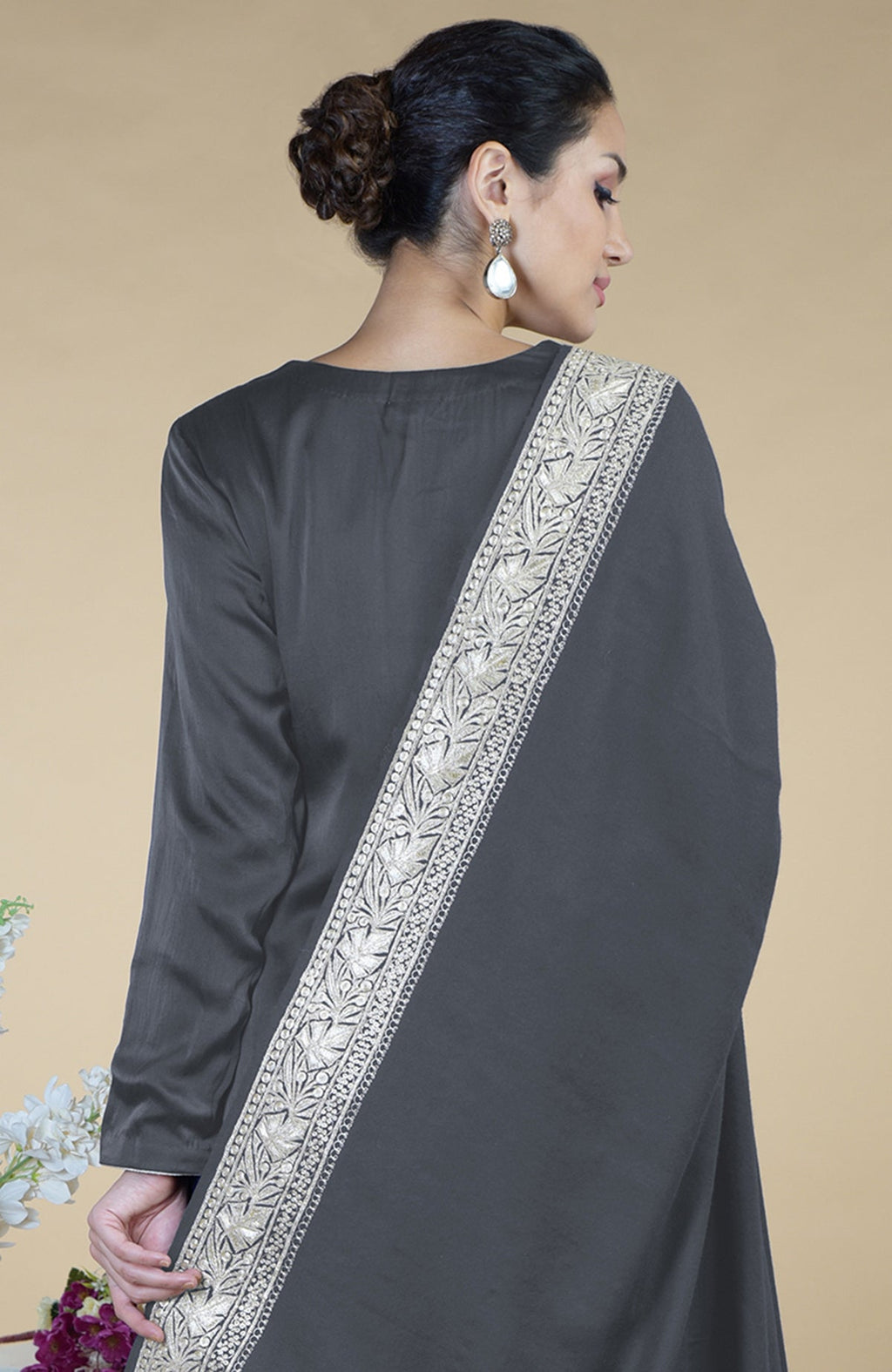 A woman models a grey silk suit with a silver embroidered dupatta.