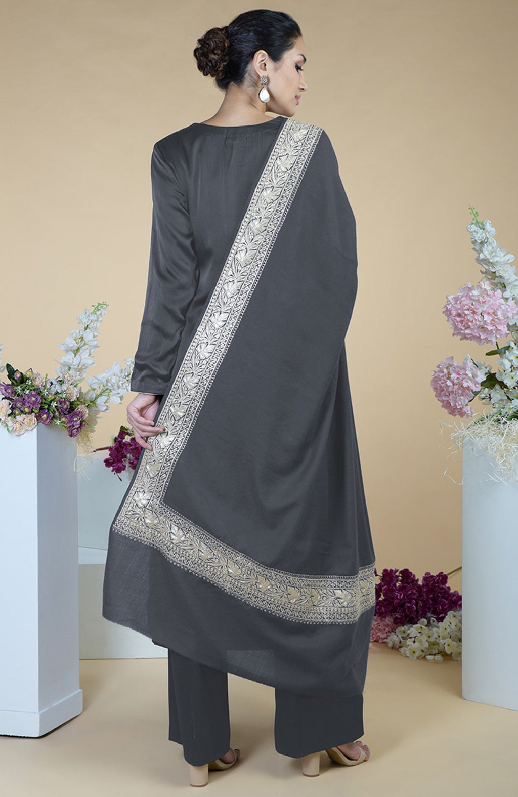 A woman from behind wears a grey Kashmiri Tilla embroidered silk dupatta with a suit.