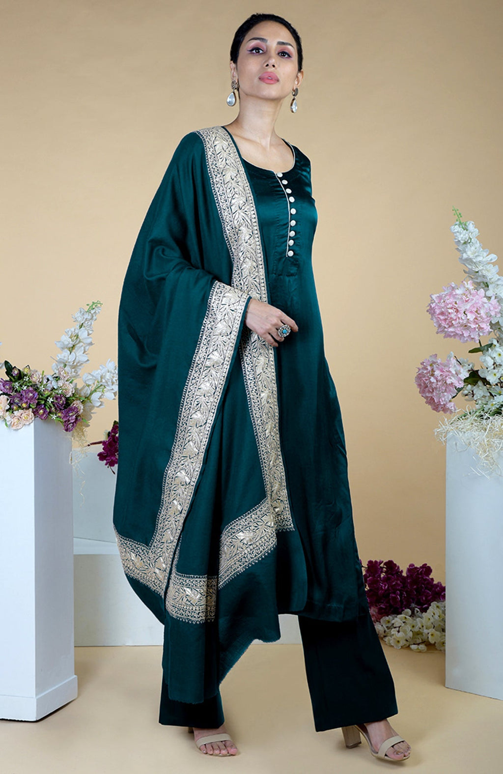 A woman models a teal silk suit with a Kashmiri Tilla embroidered dupatta.