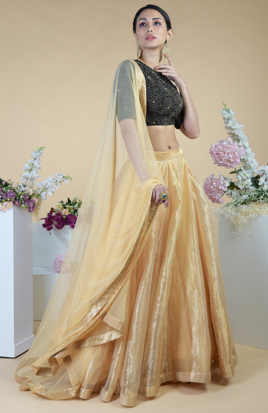 Black-gold hand-embroidered blouse with a gold tissue skirt and a sheer gold dupatta.