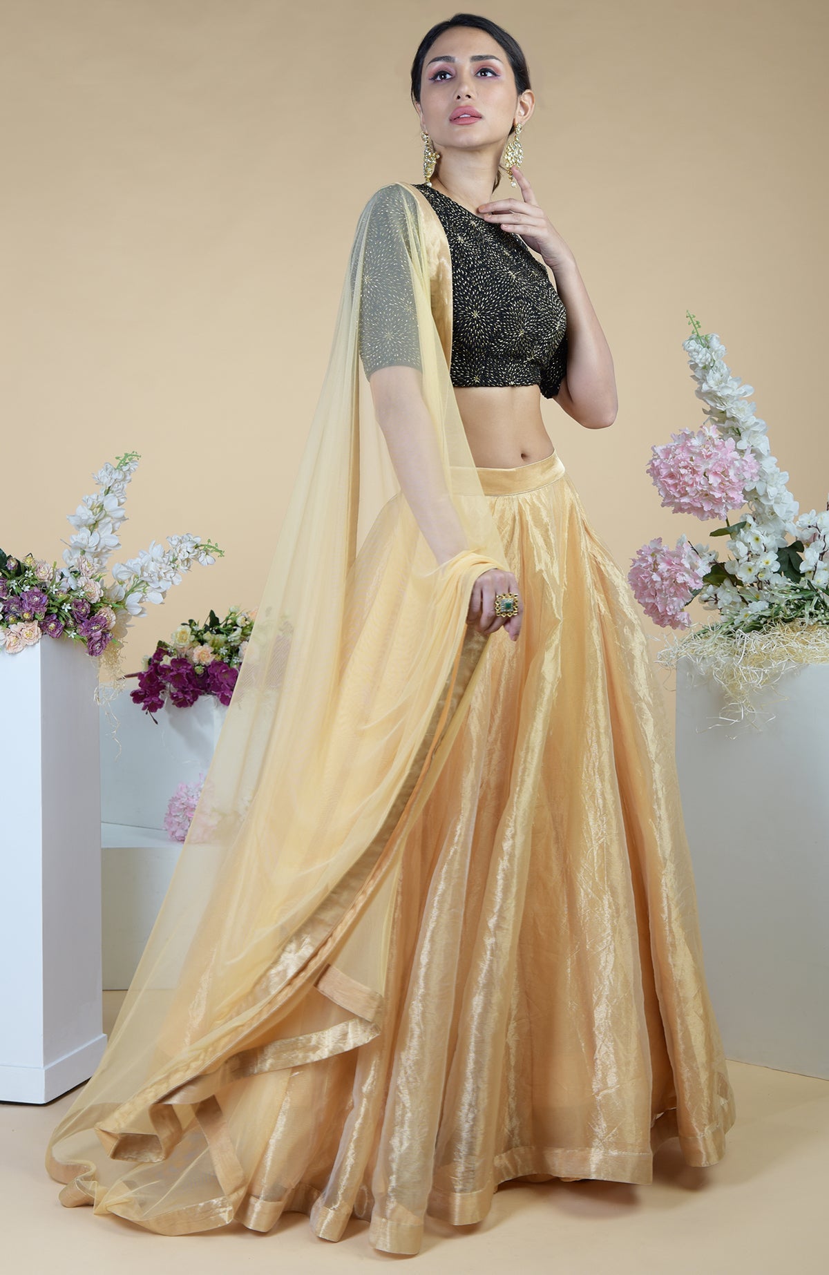 Black-gold hand-embroidered blouse with a gold tissue skirt and a sheer gold dupatta.