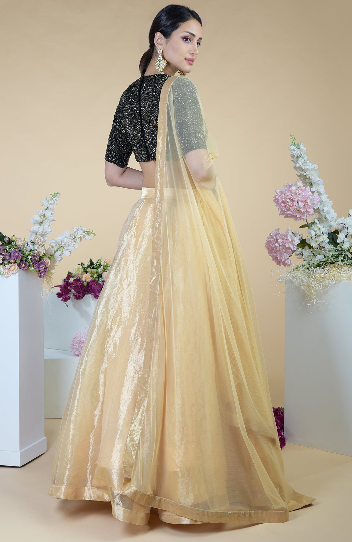 Black-gold hand-embroidered blouse with a gold tissue skirt and a sheer gold dupatta.