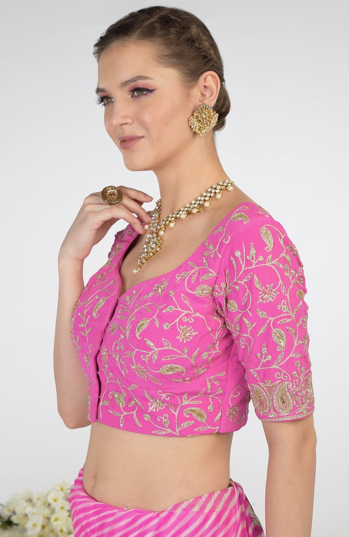 A woman models a pink leheriya saree with Kashmiri paisley tilla aari embroidery.