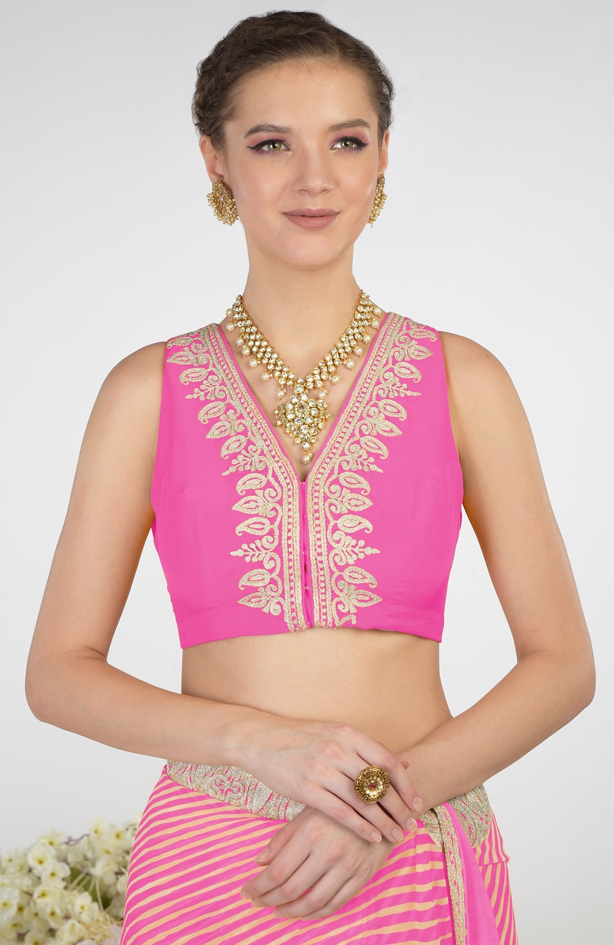 A woman models a pink leheriya saree with Kashmiri paisley tilla aari embroidery.