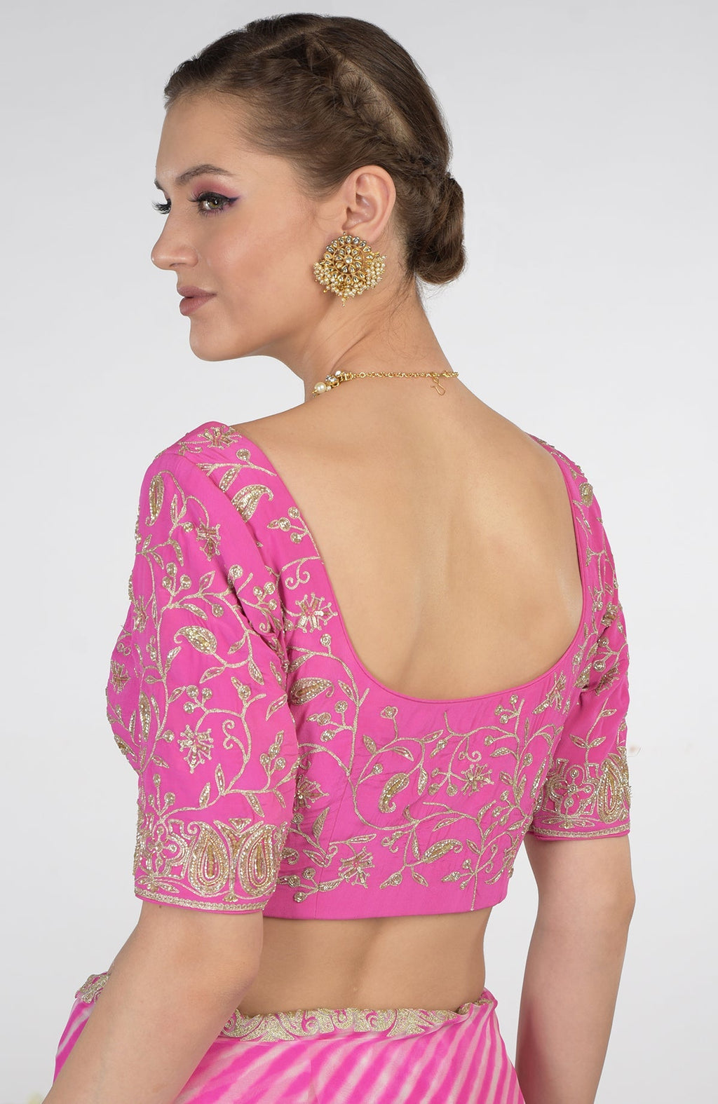 A woman models a pink leheriya Kashmiri paisley tilla aari embroidered saree.