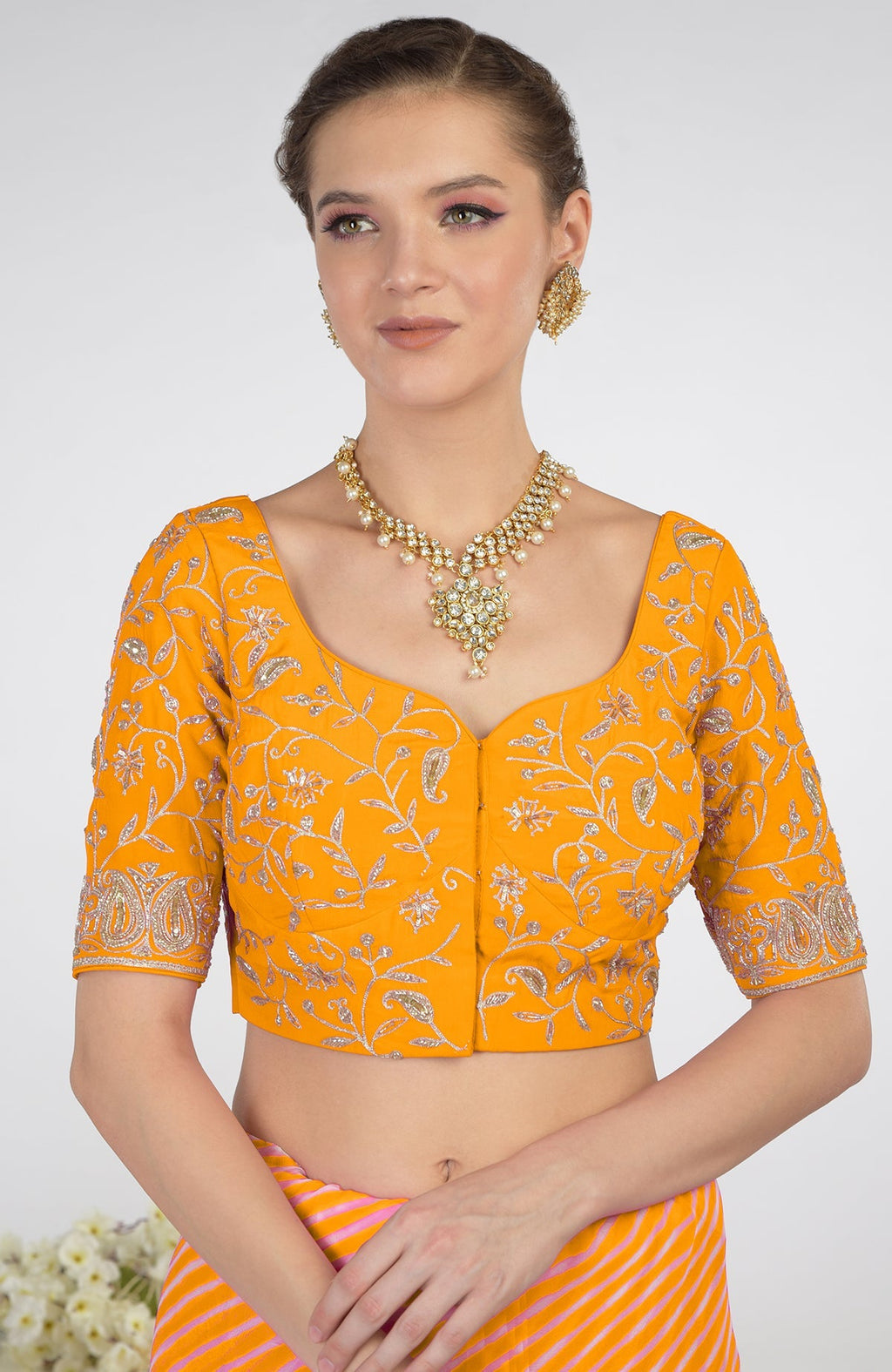 A woman models a yellow leheriya saree with Kashmiri paisley tilla aari embroidery.