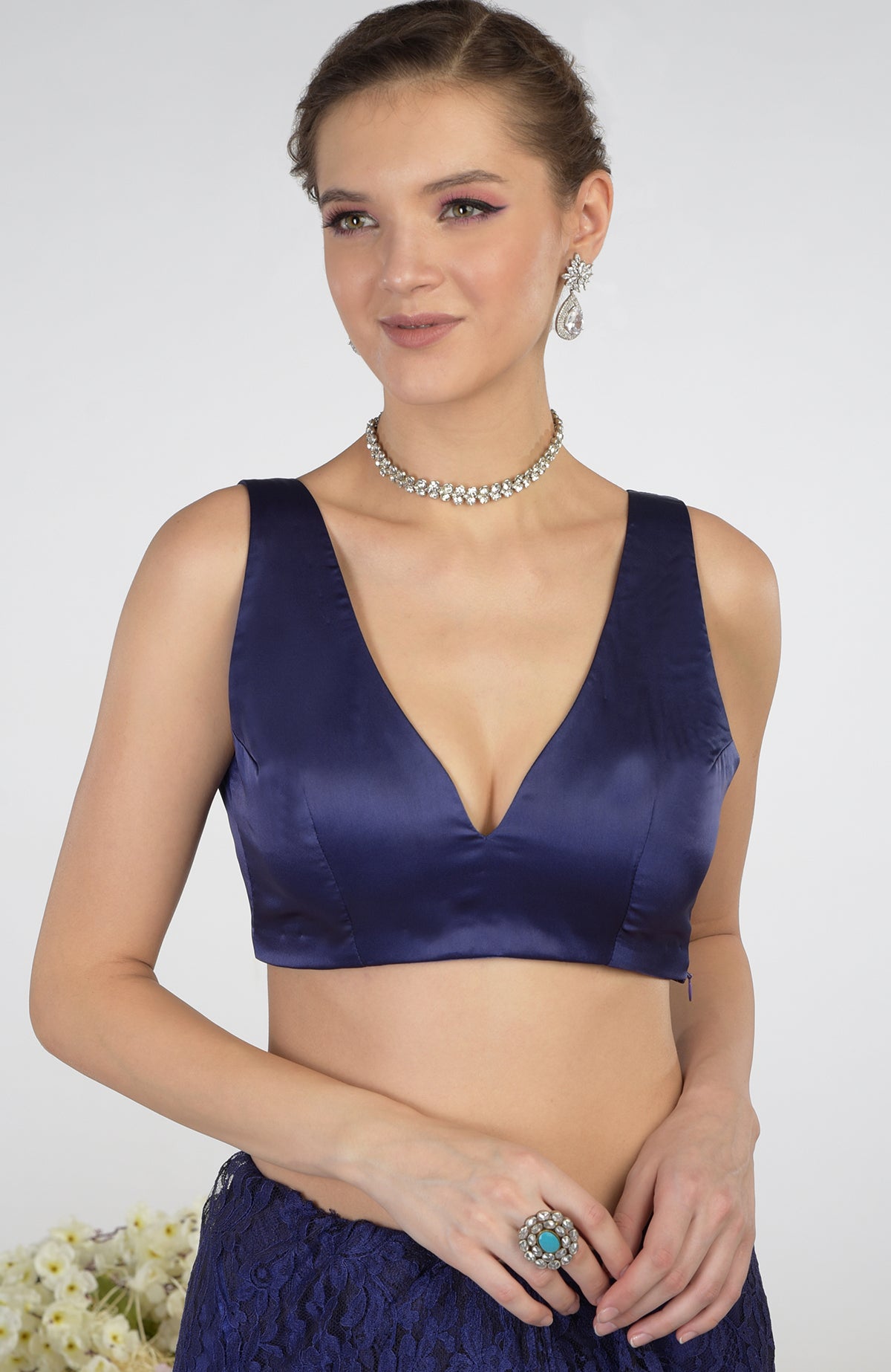 A woman models an eclipse blue French Chantilly lace saree with a satin blouse.