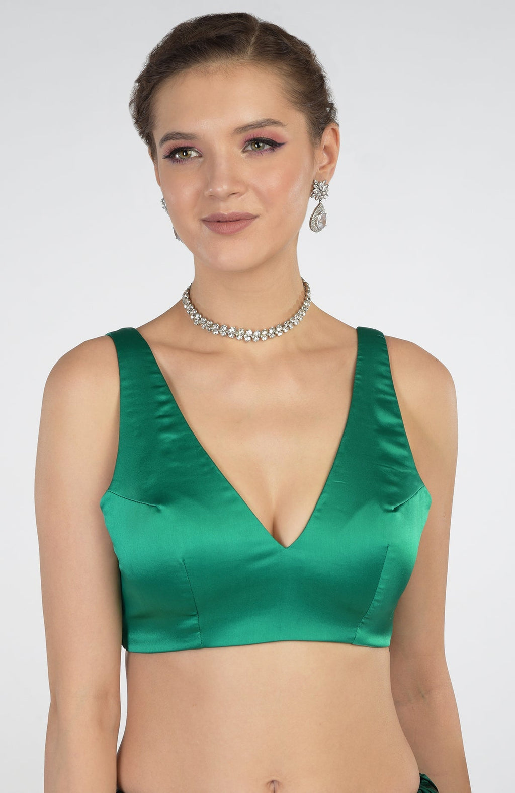 A woman models an emerald green satin blouse and a diamond choker necklace.