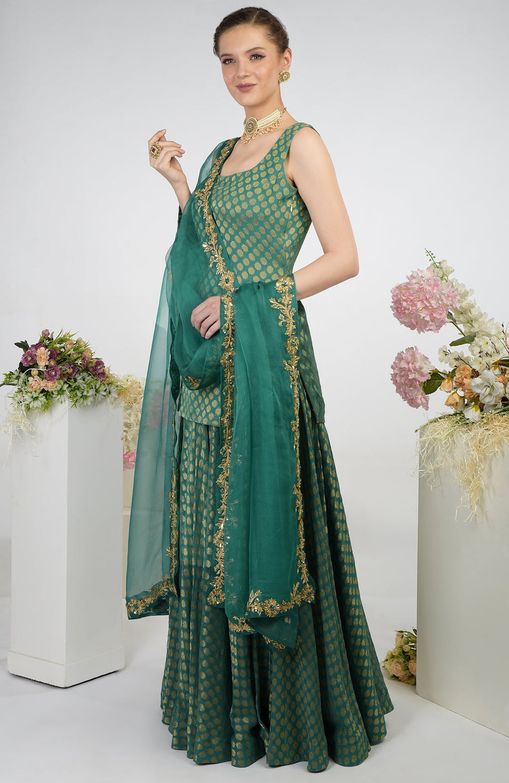 A woman models a bottle green Banarasi zardozi kalidaar skirt set.