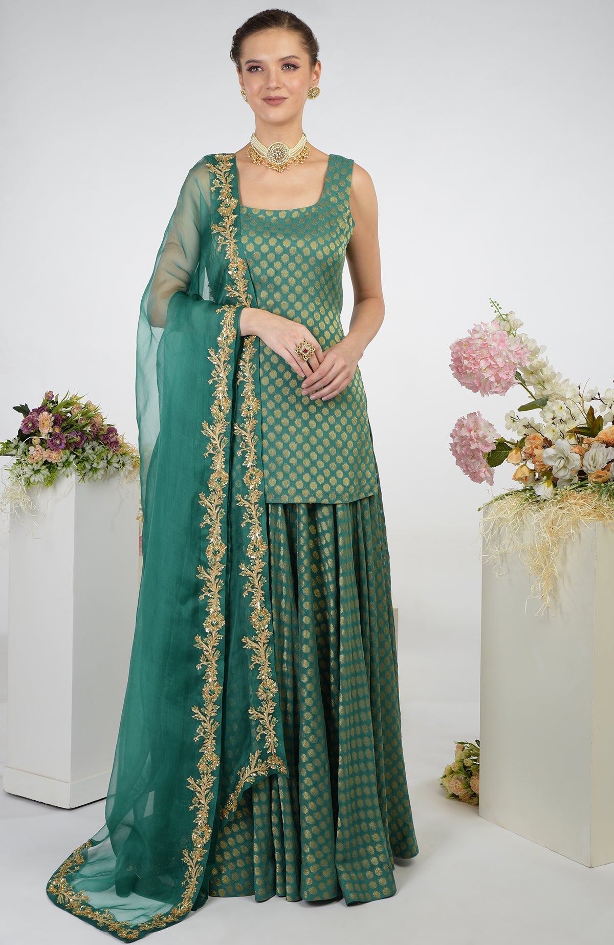 A woman models a bottle green Banarasi zardozi kalidaar skirt set.