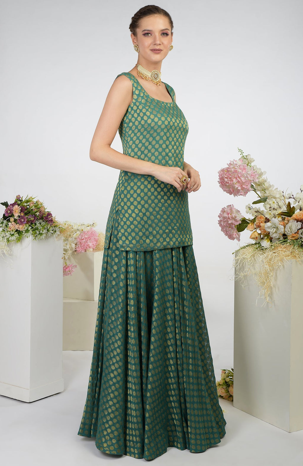 A woman models a bottle green Banarasi zardozi kalidaar skirt set with gold polka dots.