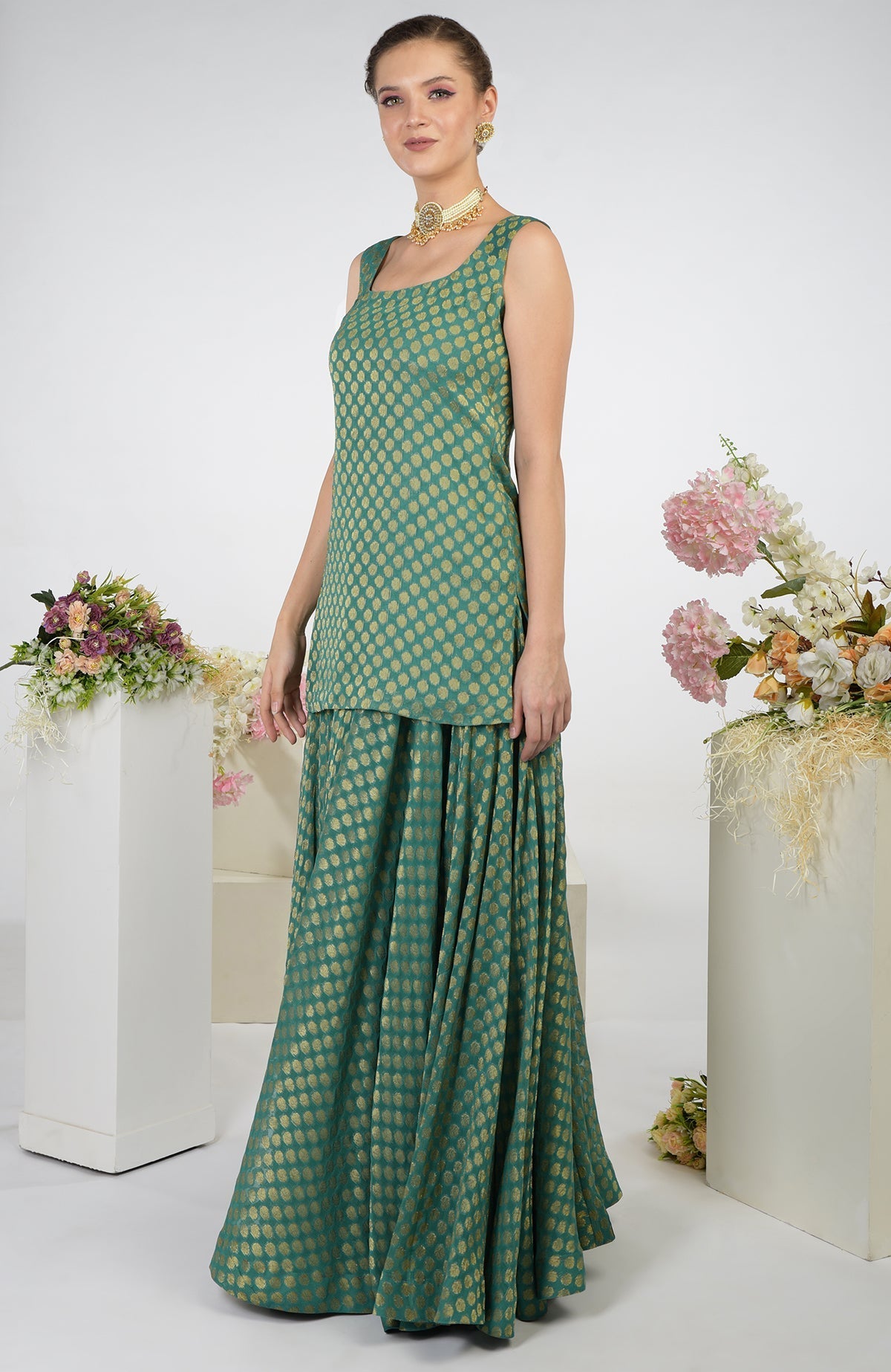 A woman models a bottle green Banarasi zardozi kalidaar skirt set.