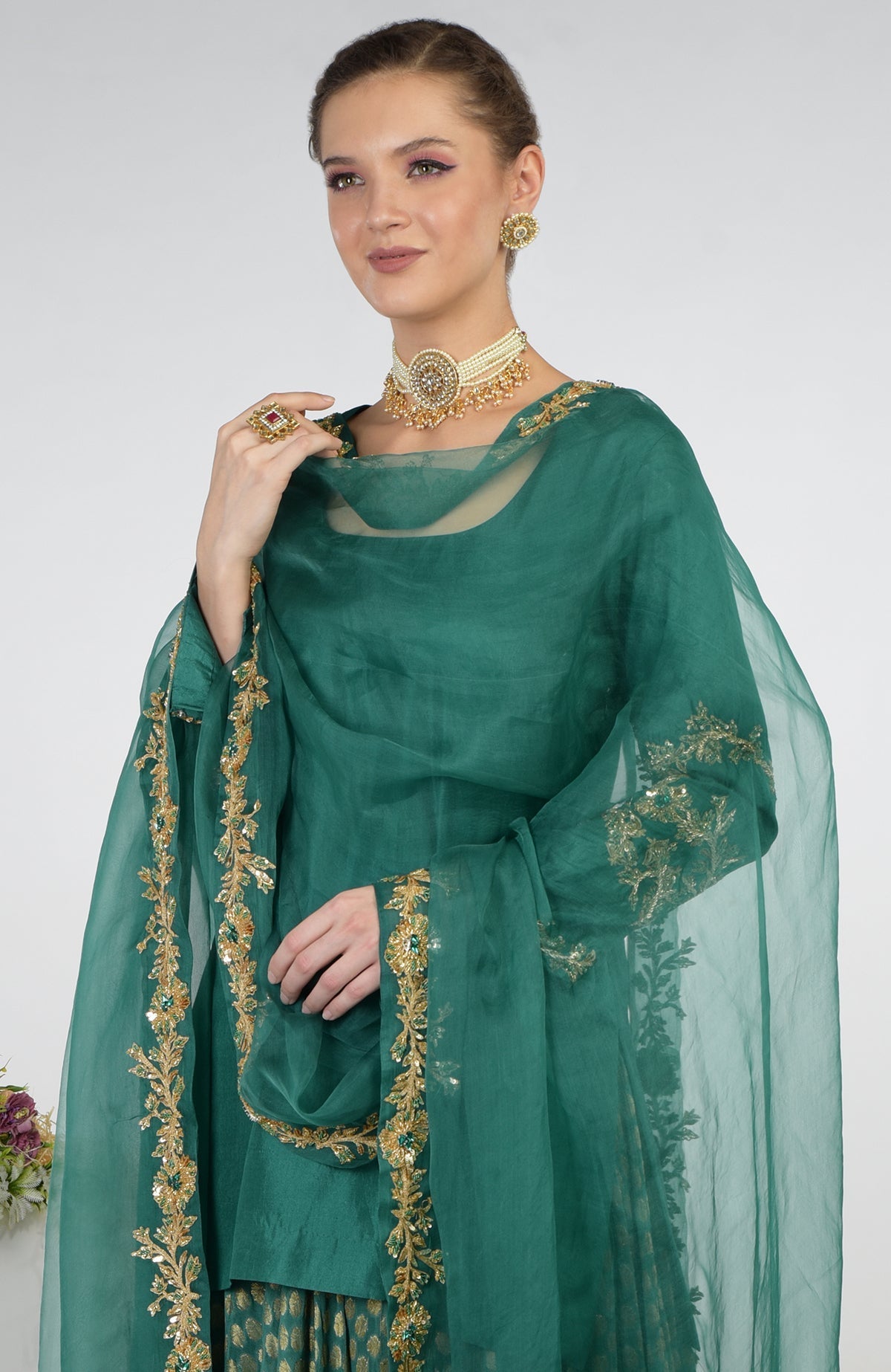 A woman models a bottle green Banarasi Zardozi Kalidaar skirt set.