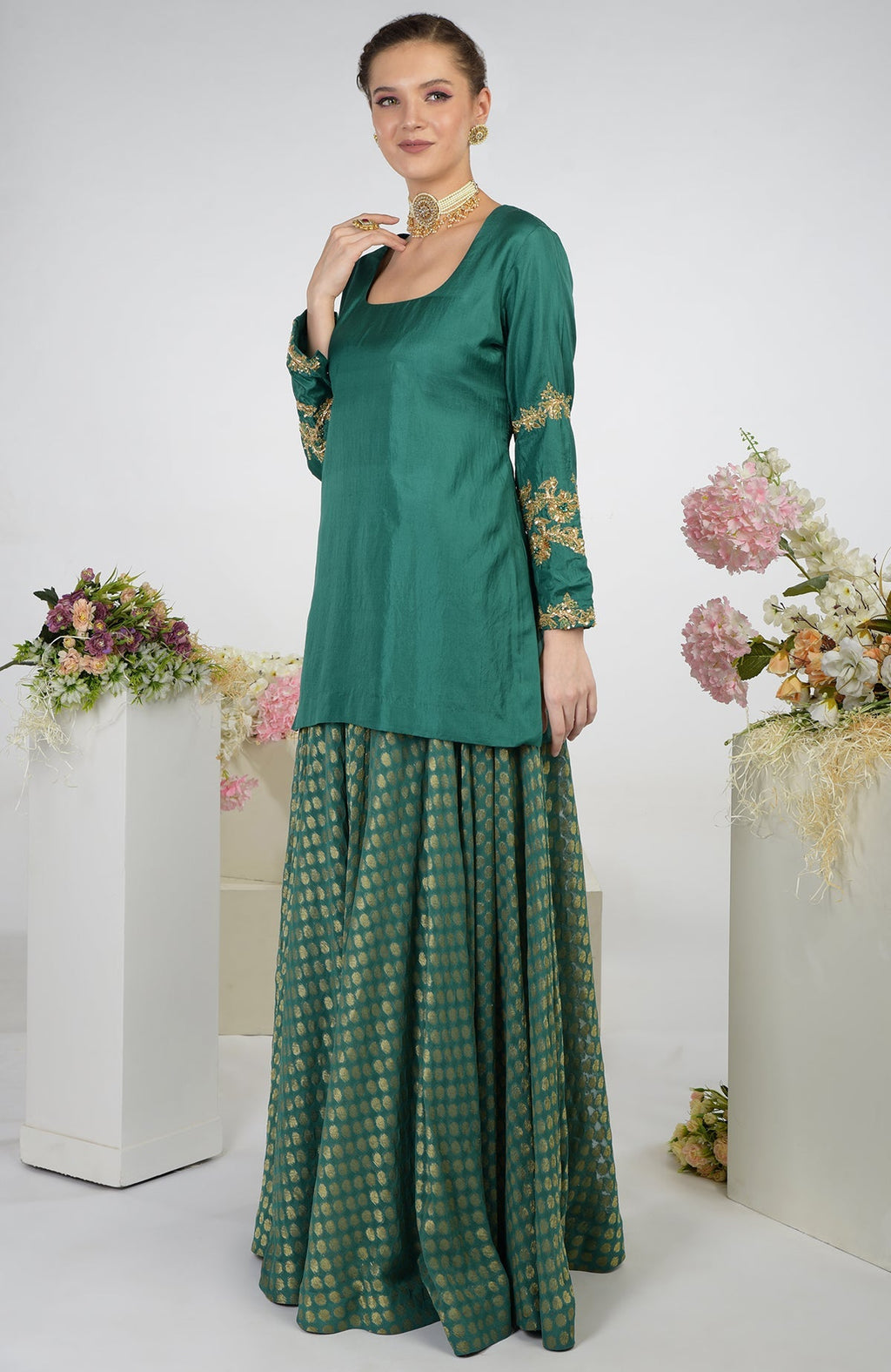 A woman models a bottle green Banarasi zardozi kalidaar skirt set.