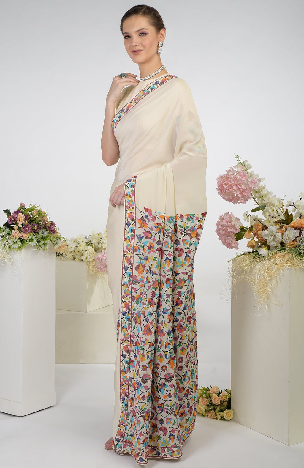 Butter cream pure crepe silk saree with multi-color Kani art embroidered floral motifs.