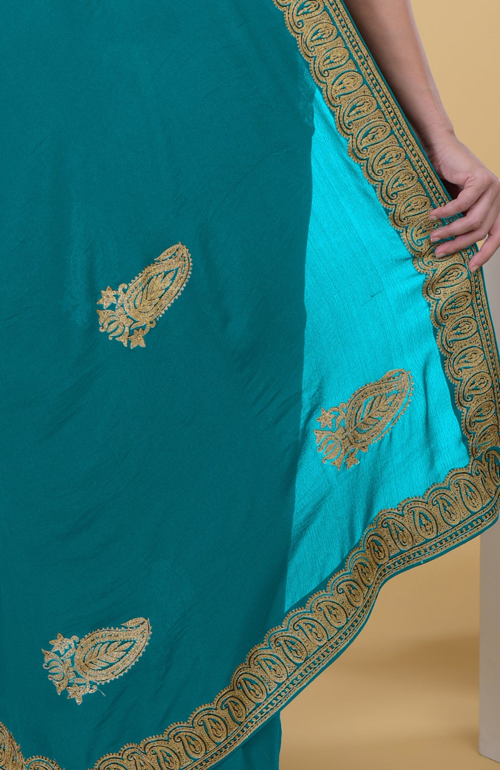 Peacock blue saree with gold Kashmiri tilla aari embroidery and paisley motifs.