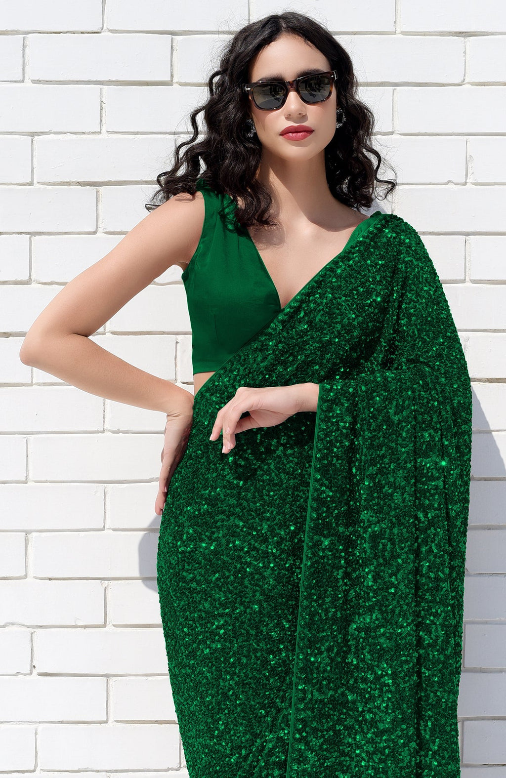 Emerald green sequin saree with a matching satin blouse.