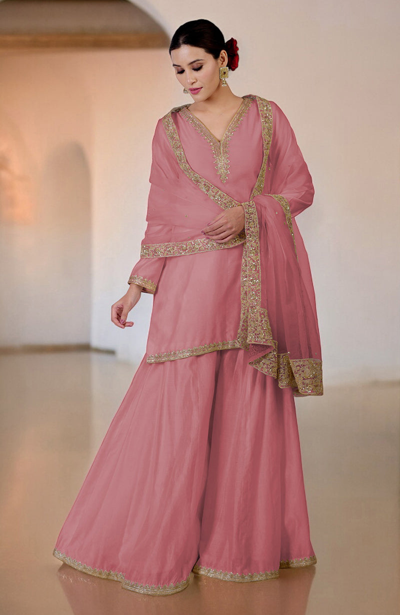 A woman models a withered rose sharara set with gold embroidery.