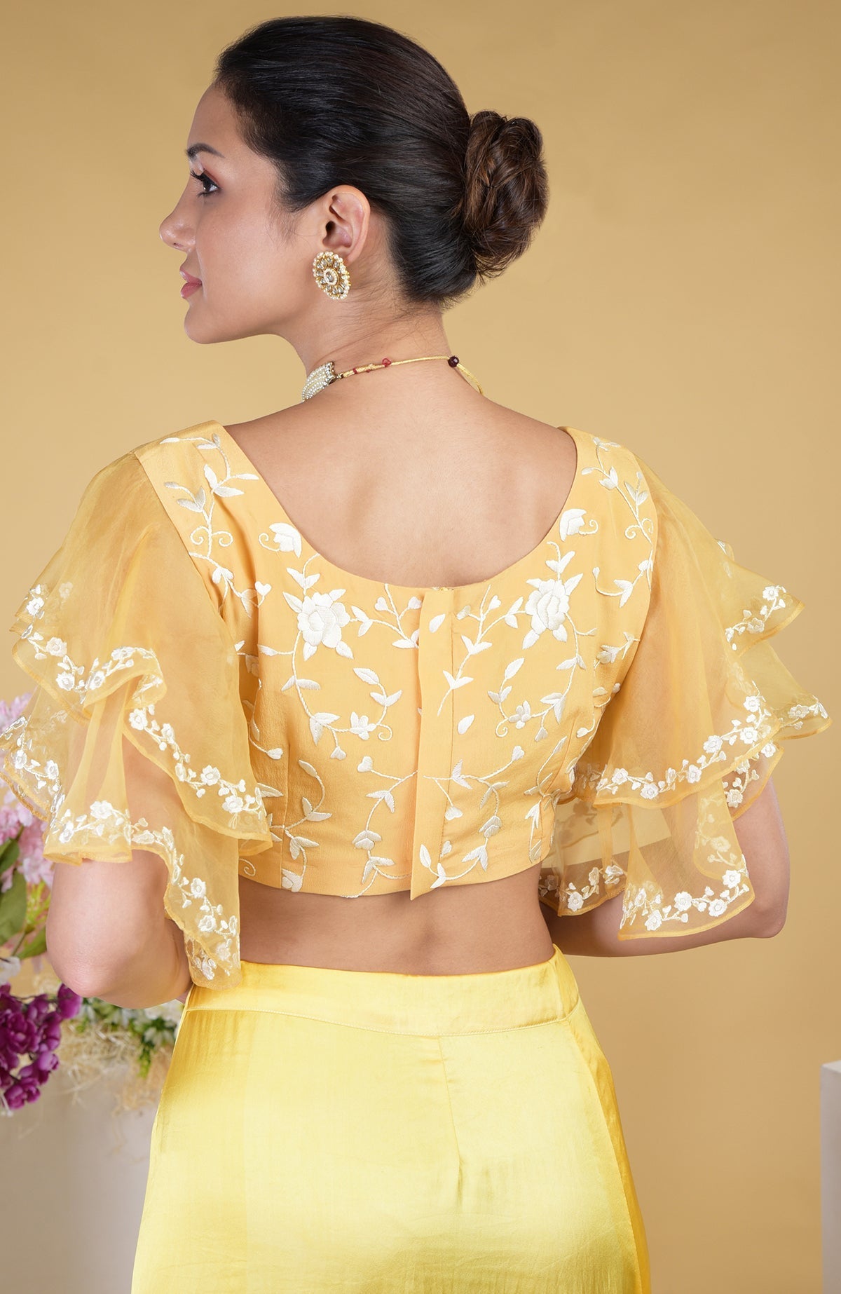 A woman models a mango yellow Parsi Gara hand-embroidered saree and blouse.