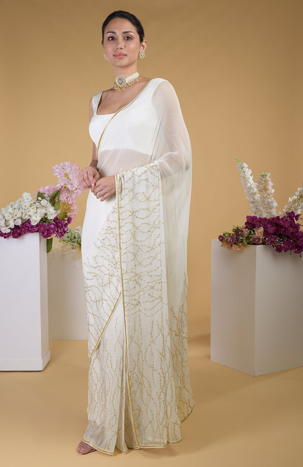 Ivory gold beads and sequin zardozi hand-embroidered saree with a scoop neck blouse.