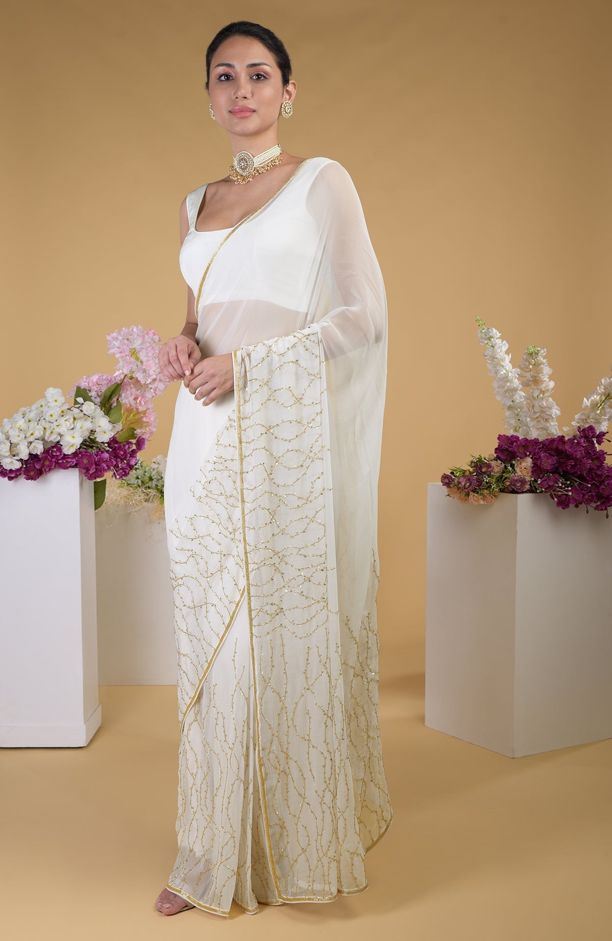 Ivory gold beads and sequin zardozi hand-embroidered saree with a scoop neck blouse.