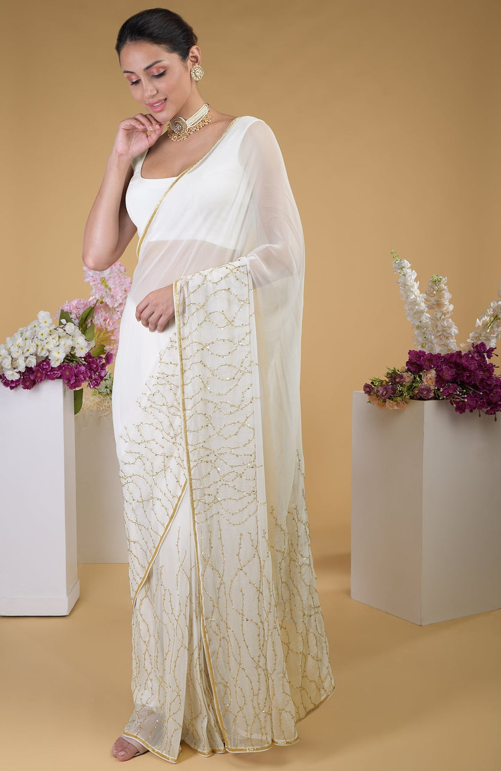 Ivory gold beads and sequin zardozi hand-embroidered saree with a scoop neck blouse.