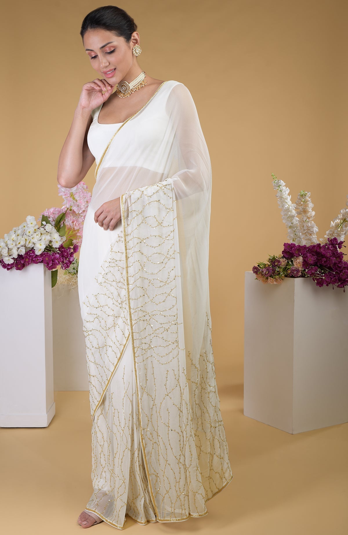 Ivory gold beads and sequin zardozi hand-embroidered saree with a scoop neck blouse.