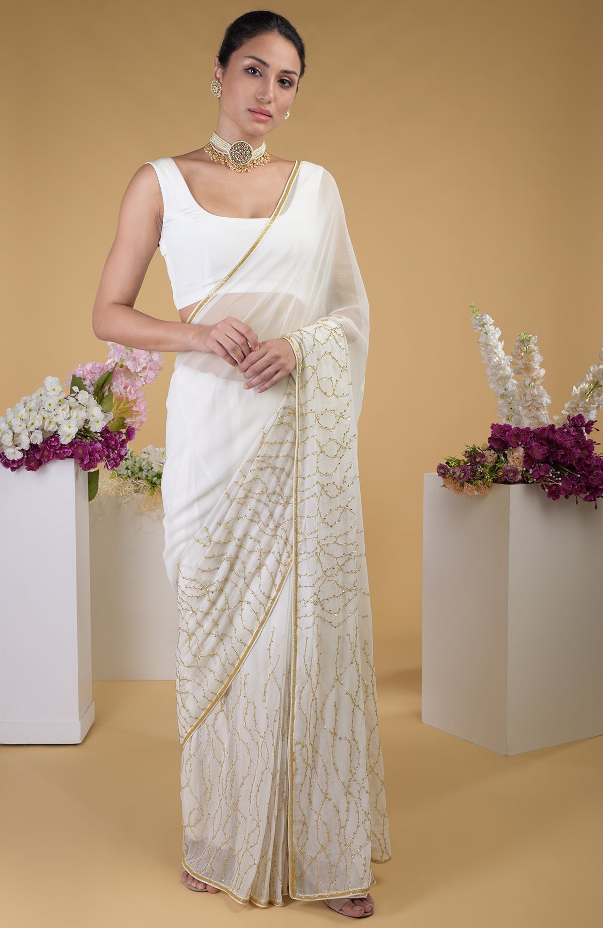 Ivory gold beads and sequin zardozi hand embroidered saree with a scoop neck blouse.