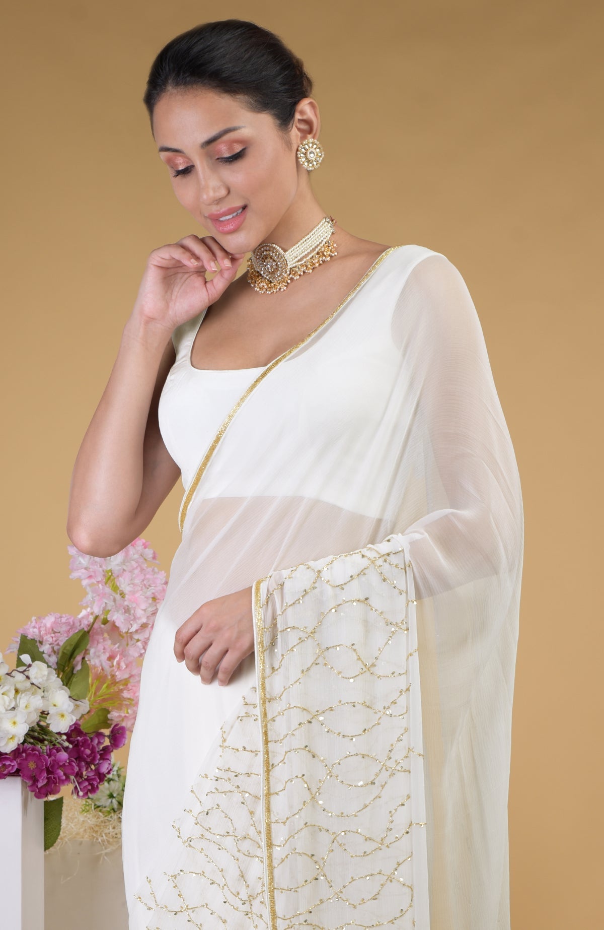 Ivory gold beads and sequin zardozi hand-embroidered saree with a scoop neck blouse.