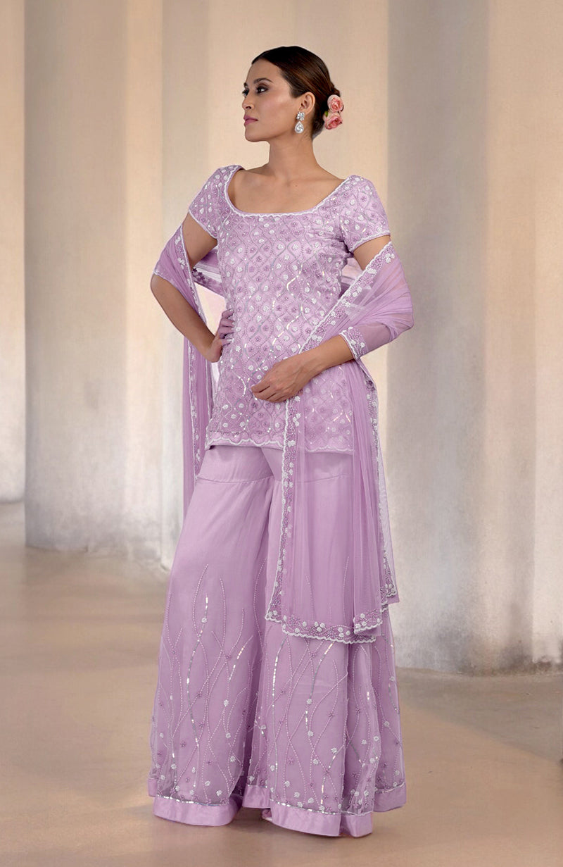 A woman models a lilac silk organza sharara set with intricate beadwork.